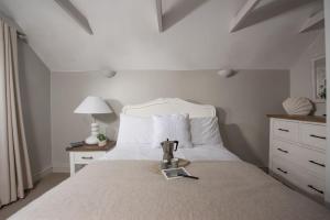 um quarto com uma cama grande e uma colcha branca em Spindrift, St Ives em St. Ives