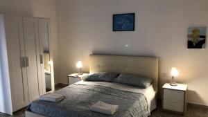 サン・ジョルジョ・イオーニコにあるCasa Antoのベッドルーム1室(ベッド1台、2つのテーブルに照明付)