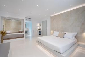 biała sypialnia z dużym białym łóżkiem w obiekcie Cycladic Suites w Firze