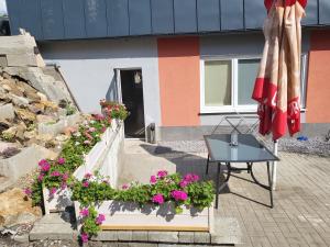 um pátio com flores e uma mesa e um edifício em Ubytovanie U Emmy em Banská Štiavnica
