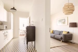 a living room with a couch and a kitchen at Casa ao Cubo in Olhão