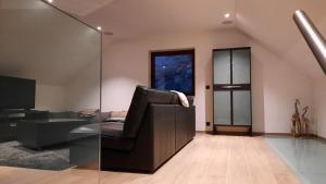 uma sala de estar com uma cadeira de couro e uma televisão em The Kettle House - Stable em Sint-Pieters-Leeuw