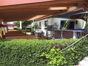 a backyard with a patio with a wooden pergola at Landgasthof Schmidbauer in Nittenau