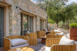 eine Terrasse mit Stühlen und Tischen sowie ein Gebäude in der Unterkunft Hôtel Casale Olmia 