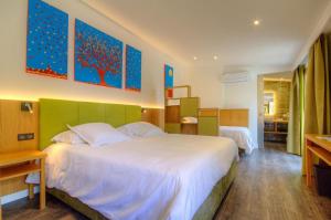 um quarto de hotel com uma cama grande e uma cozinha em Hôtel Casale Olmia 