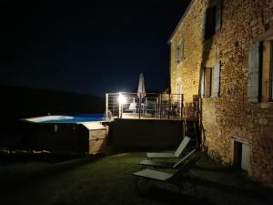 a building with a swimming pool at night at Maison typique périgourdine avec piscine in Paulin