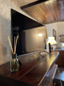 a wooden table with bamboo sticks in a vase on it at Casa Belvedere Sant’Anna in Rivisondoli