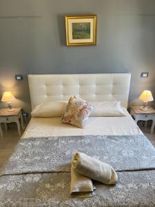 ein Schlafzimmer mit einem großen weißen Bett mit zwei Tischen in der Unterkunft SUITE Casa MARA & SUITE Casa TEA in Maratea