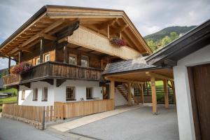 a large wooden house with a balcony at Ferienwohnung Kast'l in Alpbach