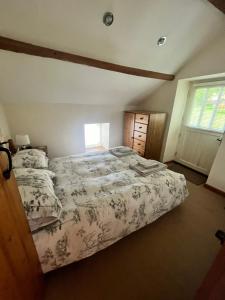 a bedroom with a large bed and a window at Prospect Farm Cottages in Allerston