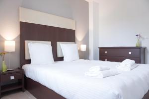 a bedroom with a large white bed with towels on it at Zenitude Hôtel-Résidences Toulon Six Fours in Six-Fours-les-Plages