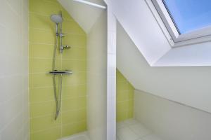 y baño con ducha de azulejos amarillos. en Maison 6 personnes avec accès privé à la plage !, en Penvins 21 fotos más