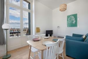 sala de estar con mesa y sofá azul en Charmant appartement vue mer au coeur du Croisic, en Le Croisic