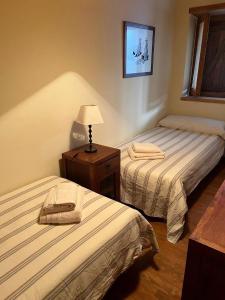 a hotel room with two beds and a table with a lamp at Vistas Sant Climent Taüll in Taüll