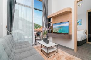 uma sala de estar com um sofá e uma televisão em Grand Kata VIP - Kata Beach em Kata Beach