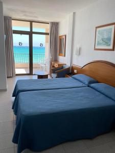 a hotel room with a bed and a view of the ocean at Hotel Marina Playa De Palma in El Arenal