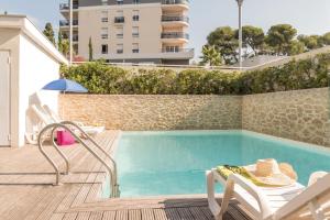 una piscina con una silla, una mesa y un visor en Appart'City Classic Antibes, en Antibes