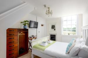 a bedroom with a bed and a dresser and a tv at The Retreat New Forest, Hinton in Christchurch