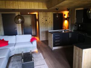 een woonkamer met een witte bank en een keuken bij Bortelid Booking in Tjaldal