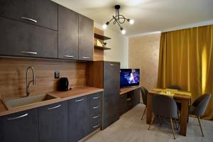 a kitchen with a sink and a table with chairs at Apartment Orpheus in Velingrad