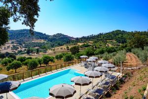 a swimming pool with umbrellas and a pool at Il Castagno Toscana Glamping in Campiglia Marittima