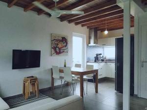 cocina y comedor con mesa y sillas en Casa cerca de la playa Casa da Cuncheira, en Carnota