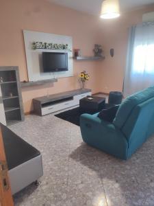 sala de estar con sofá azul y TV de pantalla plana en BIG DREAMS Al en Vila do Conde