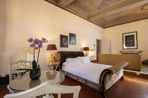 a bedroom with a bed and a table and a couch at Palazzo Martellini Residenza d'epoca in Florence