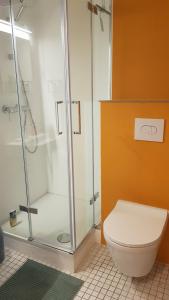 a bathroom with a glass shower and a toilet at Brunnenputzer Pension Restaurant in Külsheim