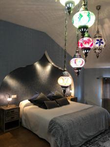 a bedroom with a large bed with chandeliers at Hospedería Casa Martell in Daroca