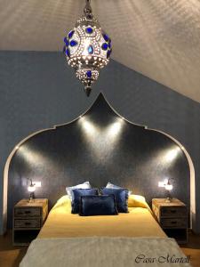 um quarto com uma cama grande e um lustre em Hospedería Casa Martell em Daroca