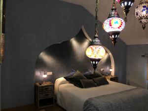 達羅卡的住宿－Hospedería Casa Martell，一间卧室配有一张带两盏灯和两张桌子的床。