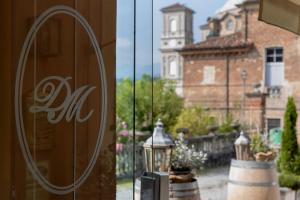 une fenêtre reflétant un bâtiment avec une tour d'horloge dans l'établissement Duchessa Margherita Chateaux & Hotels, à Vicoforte