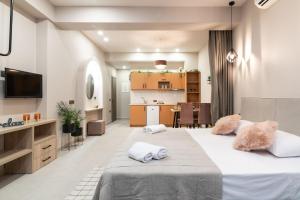 a bedroom with a large bed and a kitchen at Bella Vacanza Studios in Zakynthos Town