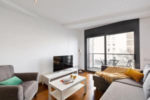 a living room with a couch and a tv at Les Corts Exclusive Apartments by Olala Homes in Barcelona