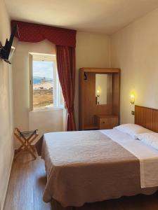 a bedroom with a bed, chair and a window at Hotel Umbria in Perugia