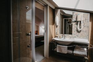łazienka z umywalką i lustrem w obiekcie Hotel Villa Eugenia w mieście Lovran