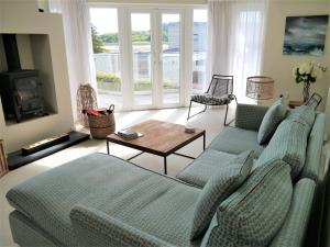 a living room with two blue couches and a table at Driftwood in Kippford