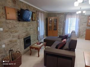 a living room with a couch and a fireplace at Casa Sambinho Gerês in Rio Caldo