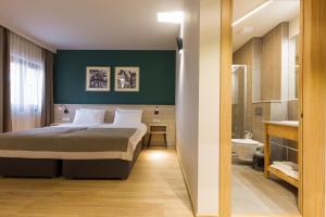 a bedroom with a large bed and a bathroom at Casa Calfelor Kolping Timișoara in Timişoara +41 photos