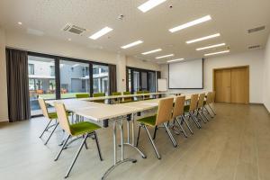 une salle de conférence avec une grande table et des chaises dans l'établissement Casa Calfelor Kolping Timișoara, à Timişoara