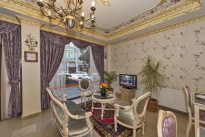 uma sala de estar com uma mesa e cadeiras e uma televisão em Istanbul Holiday Hotel em Istambul