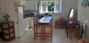 a kitchen with a table and chairs and a refrigerator at Black Rock Haven in Scottburgh