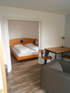 1 dormitorio con 2 camas, mesa y sofá en Einbecker Sonnenberg, en Einbeck