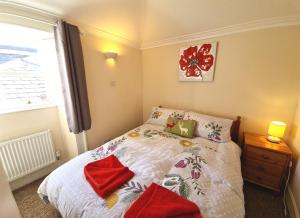 East Wing Apartment in Elgin في إلجين: غرفة نوم مع سرير وفوط حمراء عليه
