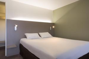 - un grand lit avec 2 oreillers dans l'établissement Kyriad Annecy Nord - Epagny, à Metz-Tessy