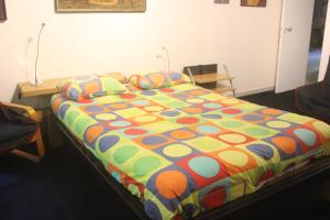 a bed with a colorful comforter in a room at B&B Middelheim in Antwerp