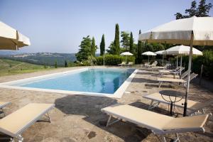 a swimming pool with lounge chairs and umbrellas at Il Rosolaccio in San Gimignano