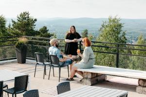 two women are sitting on a bench on a balcony at Lapland Hotels Sky Ounasvaara in Rovaniemi +37 photos