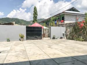 een patio met een wit hek en een gebouw bij RedDoorz @ Jalan Gelanggang Remaja Waena Jayapura in Sentani